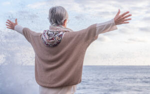 rear view of caucasian senior woman in front to the sea at sunse
